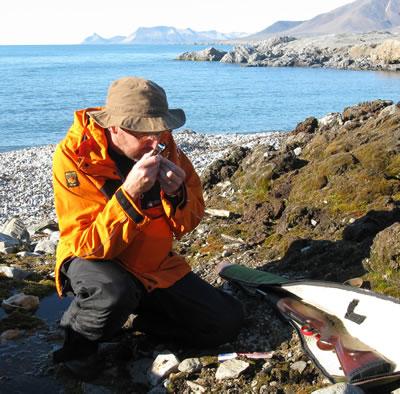 Dr Kevin Newsham of the British Antarctic Survey looking for liverworts at Hansneset on Blomstrandhalvöya, an island north of Ny-Ålesund. Note the rifle to warn off inquisitive polar bears!